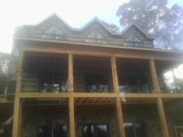 Dormers and porch framing on a large log home under construction — Roof Coating work by our crew in Abingdon